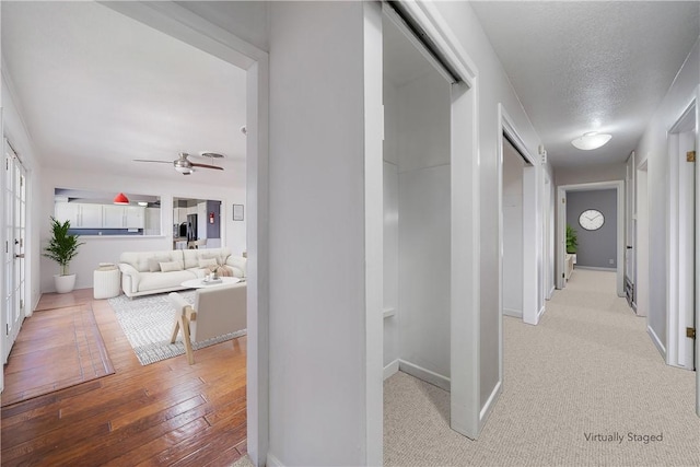 hall featuring a textured ceiling and light wood-type flooring