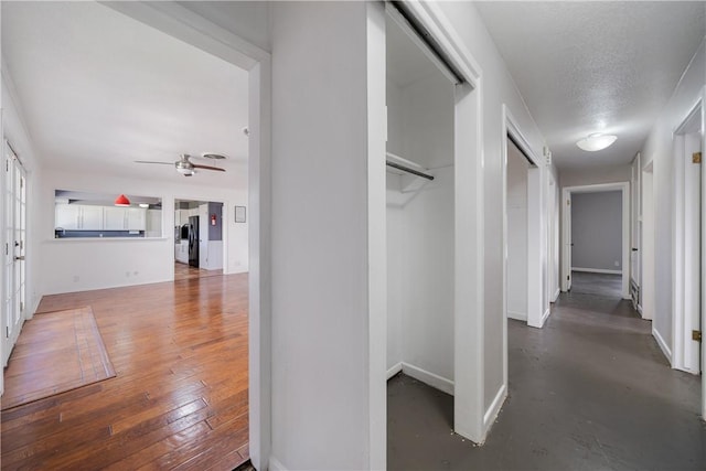 hall featuring dark wood-type flooring and a textured ceiling