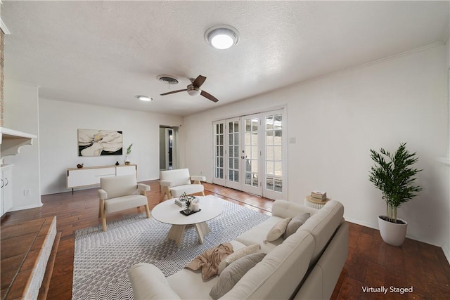 living room featuring ceiling fan, french doors, dark hardwood / wood-style floors, and a textured ceiling