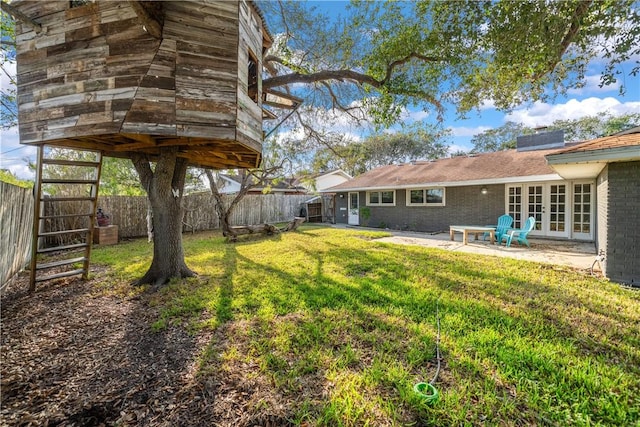 view of yard featuring french doors, a fenced backyard, and a patio
