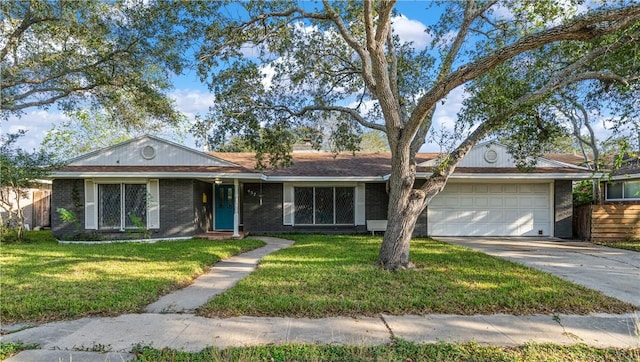 ranch-style home with concrete driveway, a front yard, brick siding, and an attached garage
