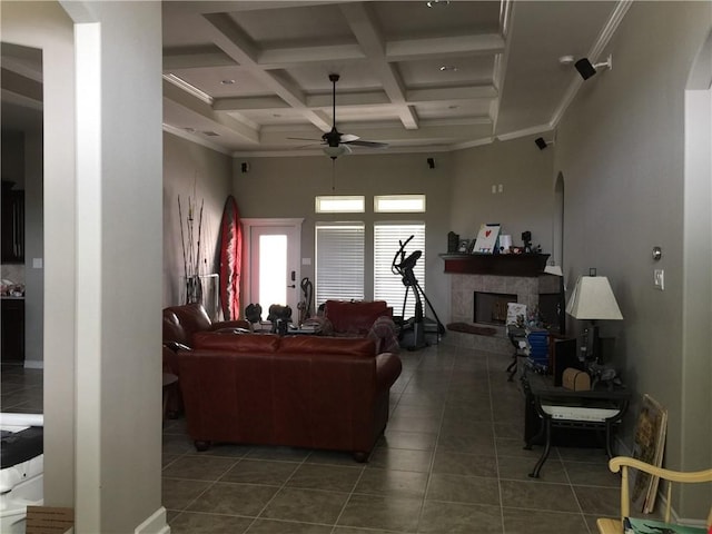 15533 Dyna St, Corpus Christi, TX 78418 - tiled living area with coffered ceiling, ceiling fan, arched walkways, a tile fireplace, and a high ceiling
