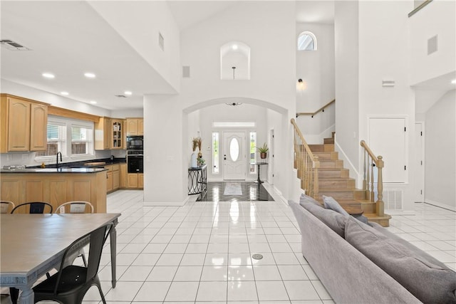 650 S Bay St, Aransas Pass, TX 78336 - entrance foyer featuring arched walkways, a towering ceiling, plenty of natural light, light tile patterned floors, and stairway