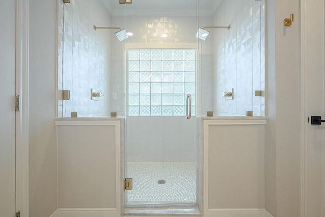 bathroom with a shower with shower door and ornamental molding