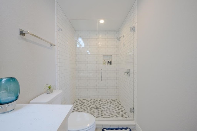 bathroom featuring toilet, vanity, an enclosed shower, and tile patterned flooring