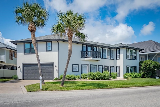 view of front facade with a balcony, a front yard, and a garage