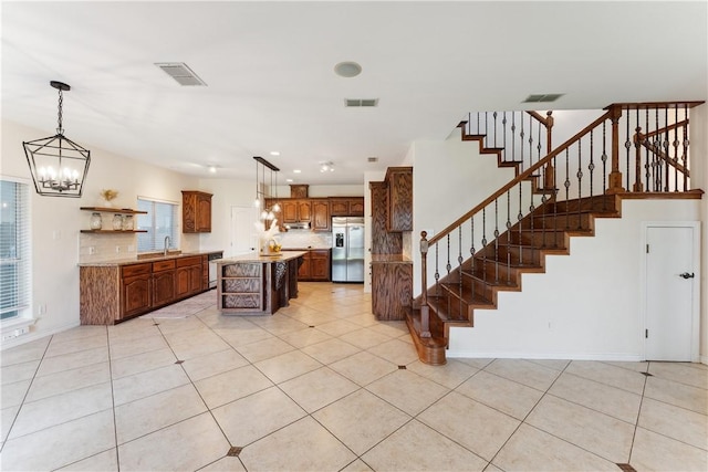 6530 Picante Dr, Corpus Christi, TX 78414 - kitchen with stainless steel fridge with ice dispenser, open shelves, decorative backsplash, light countertops, and a kitchen island