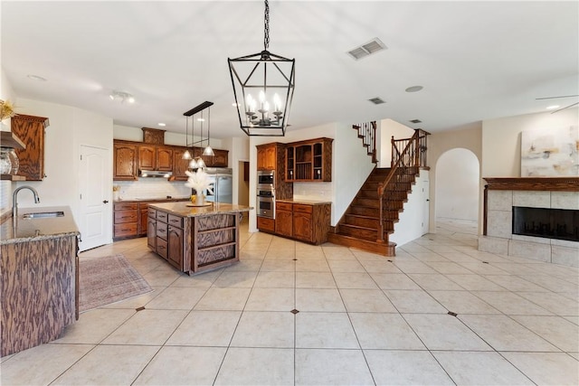 6530 Picante Dr, Corpus Christi, TX 78414 - kitchen with backsplash, open floor plan, open shelves, a tile fireplace, and stainless steel appliances