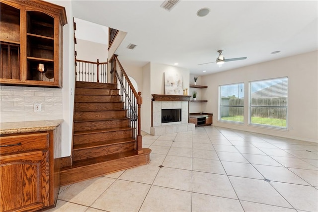 6530 Picante Dr, Corpus Christi, TX 78414 - unfurnished living room featuring a tiled fireplace, ceiling fan, stairs, light tile patterned floors, and recessed lighting