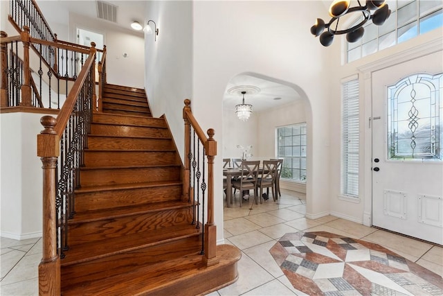 6530 Picante Dr, Corpus Christi, TX 78414 - entrance foyer featuring arched walkways, a chandelier, light tile patterned floors, a towering ceiling, and stairs