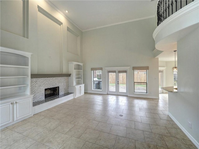 6134 Strasbourg Dr, Corpus Christi, TX 78414 - unfurnished living room with plenty of natural light, a high ceiling, french doors, a tile fireplace, and crown molding