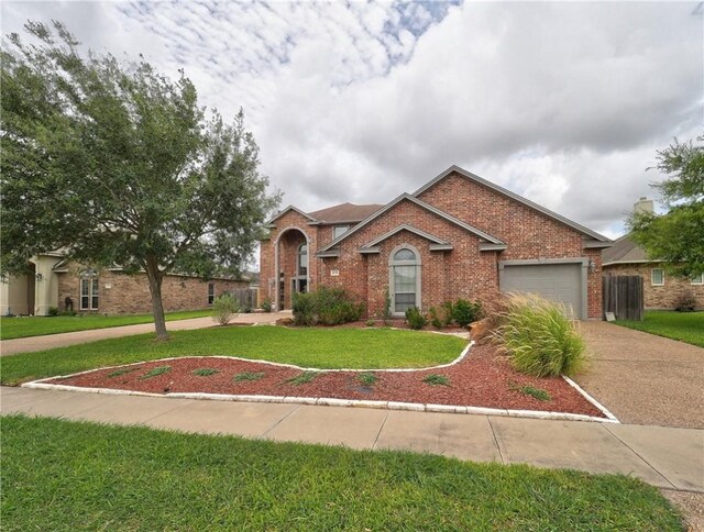 6134 Strasbourg Dr, Corpus Christi, TX 78414 - view of front of property with driveway, brick siding, a front lawn, and a garage