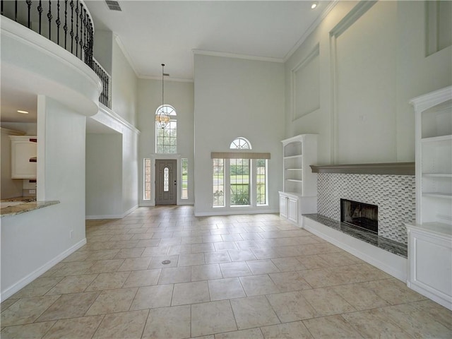 6134 Strasbourg Dr, Corpus Christi, TX 78414 - unfurnished living room with a high ceiling, ornamental molding, a tile fireplace, a chandelier, and built in features
