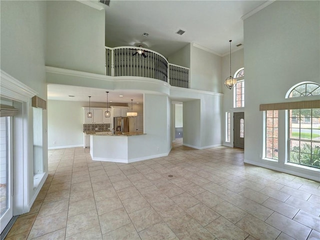 6134 Strasbourg Dr, Corpus Christi, TX 78414 - unfurnished living room with ceiling fan, a towering ceiling, a chandelier, crown molding, and light tile patterned flooring