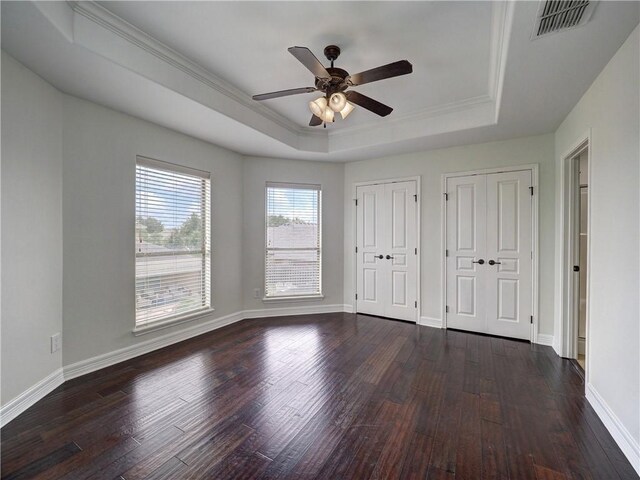 6134 Strasbourg Dr, Corpus Christi, TX 78414 - unfurnished bedroom featuring a raised ceiling, two closets, dark wood-style flooring, crown molding, and a ceiling fan