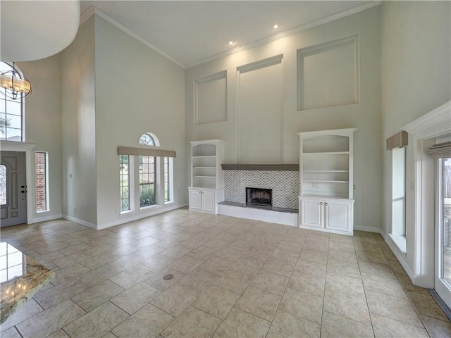 6134 Strasbourg Dr, Corpus Christi, TX 78414 - unfurnished living room featuring a towering ceiling, a fireplace, a chandelier, and crown molding