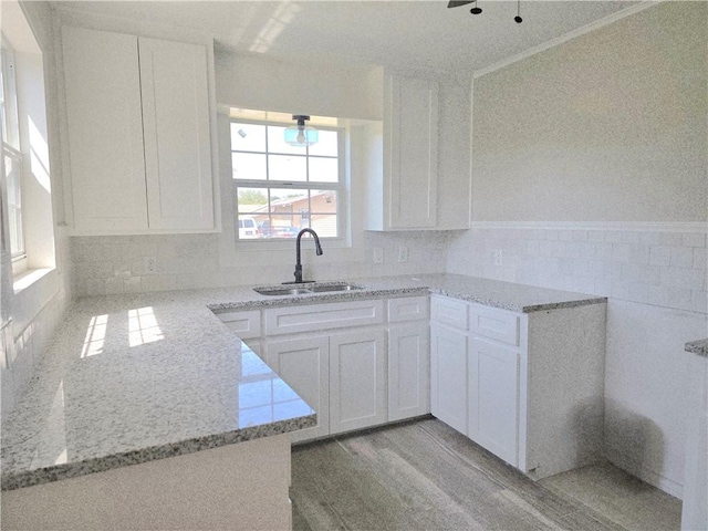 1367 Normandy Dr, Corpus Christi, TX 78415 - kitchen featuring a sink, light stone countertops, and white cabinetry