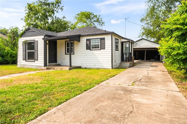 1367 Normandy Dr, Corpus Christi, TX 78415 - view of front facade featuring a front yard, driveway, a shingled roof, and a carport