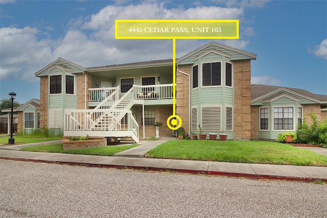 4445 Cedar Pass Dr Unit 103, Corpus Christi, TX 78413 - townhome / multi-family property featuring covered porch, a front lawn, stairs, and brick siding