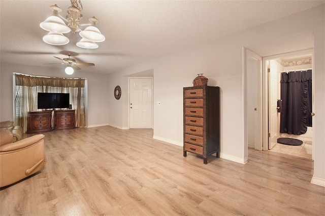 4445 Cedar Pass Dr Unit 103, Corpus Christi, TX 78413 - unfurnished living room with a chandelier, light wood finished floors, a textured ceiling, and a ceiling fan