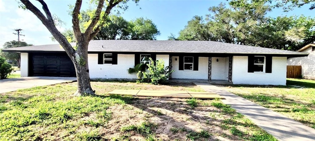 ranch-style house featuring fence, an attached garage, brick siding, concrete driveway, and covered porch