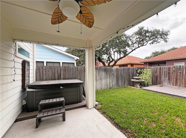 view of yard featuring ceiling fan and a hot tub