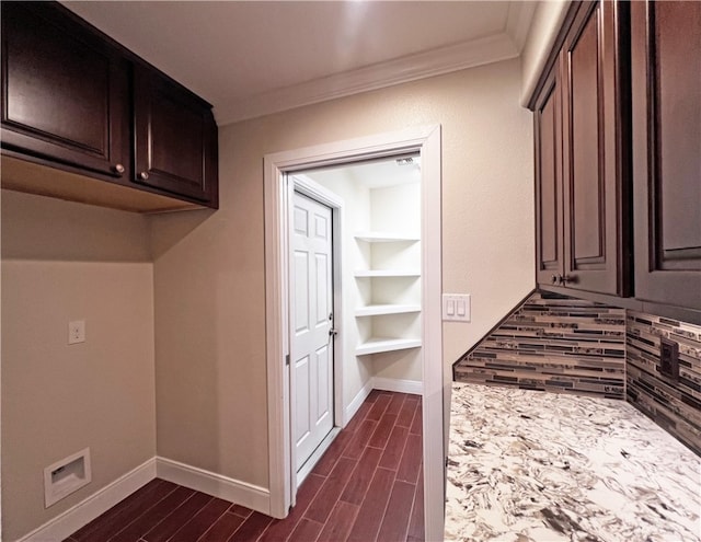 clothes washing area featuring dark hardwood / wood-style floors and ornamental molding