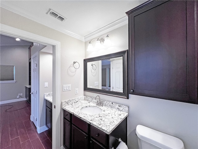 bathroom with hardwood / wood-style floors, vanity, toilet, and ornamental molding