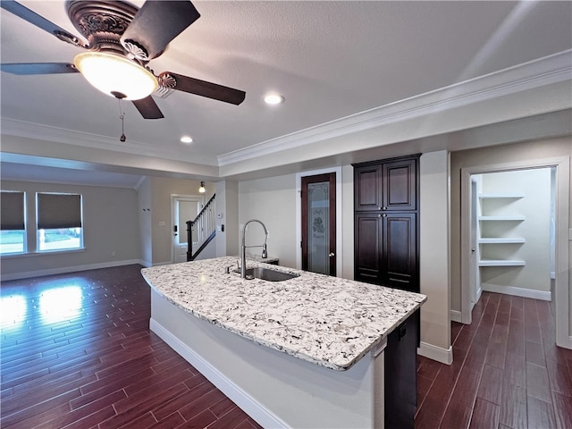 kitchen featuring a center island with sink, dark hardwood / wood-style floors, ornamental molding, and sink