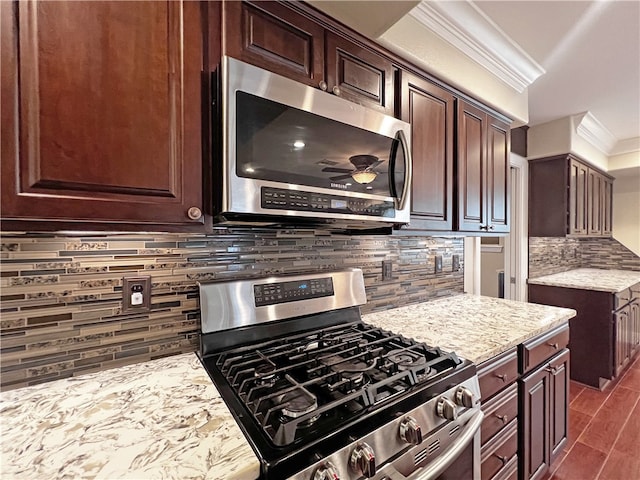 kitchen featuring decorative backsplash, appliances with stainless steel finishes, light stone countertops, ornamental molding, and dark brown cabinetry