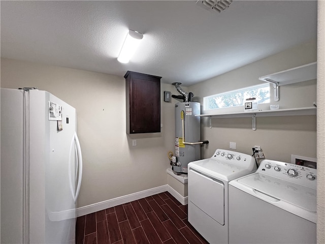 clothes washing area with water heater, washer and clothes dryer, cabinets, and dark hardwood / wood-style floors