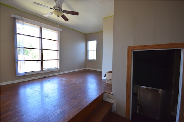 empty room with dark wood-type flooring and ceiling fan