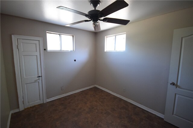 empty room featuring ceiling fan and plenty of natural light