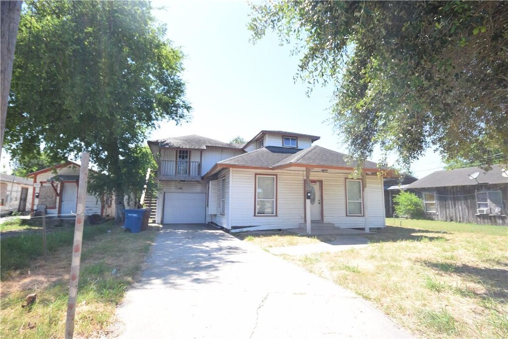 2845 Blake St, Corpus Christi, TX 78405 - view of front of home with asphalt driveway, covered porch, a garage, a front lawn, and a shingled roof