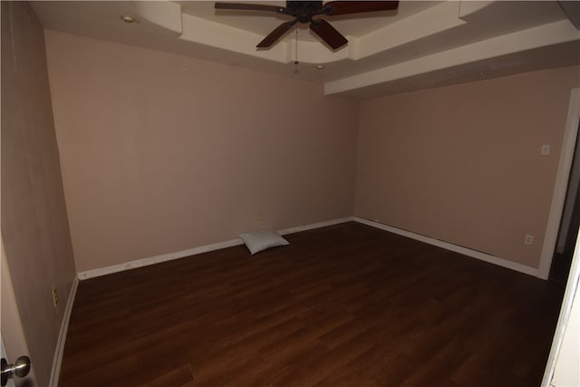 unfurnished room featuring ceiling fan, dark hardwood / wood-style floors, and a raised ceiling