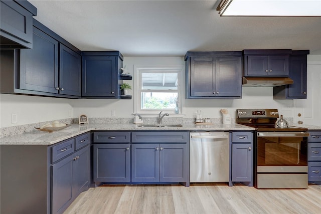 kitchen featuring light wood-type flooring, appliances with stainless steel finishes, sink, and light stone counters