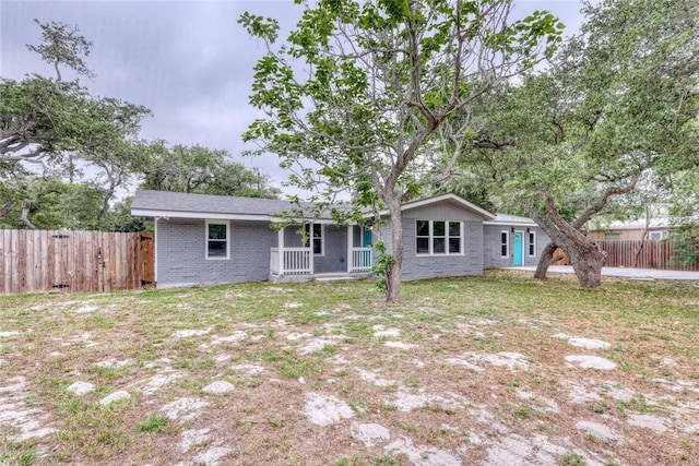 back of property featuring covered porch and a yard