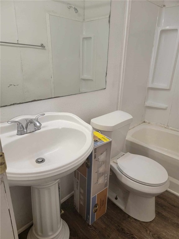 bathroom with shower / bathing tub combination, hardwood / wood-style flooring, and toilet