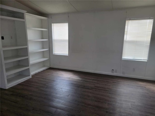 unfurnished room featuring plenty of natural light, lofted ceiling, and dark wood-type flooring