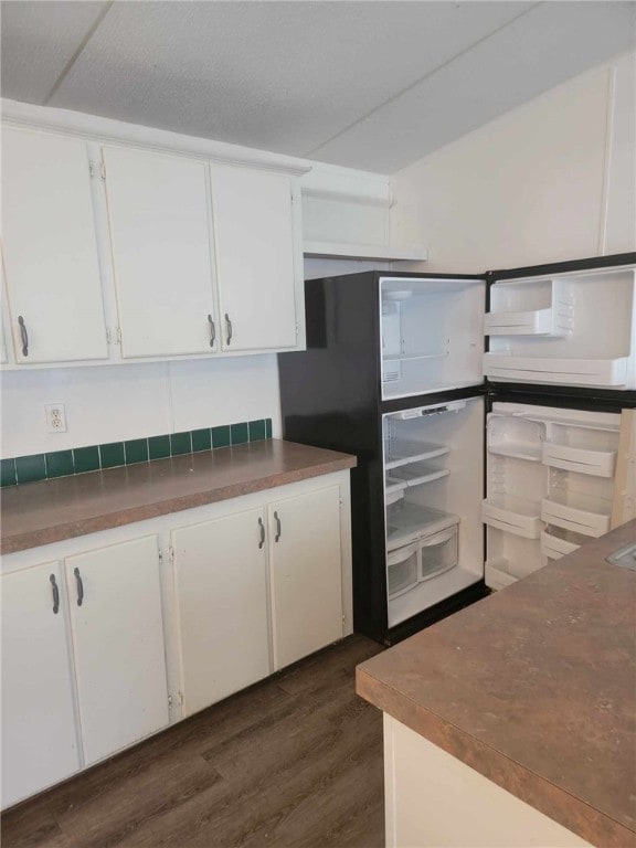 kitchen with dark hardwood / wood-style flooring and white cabinets