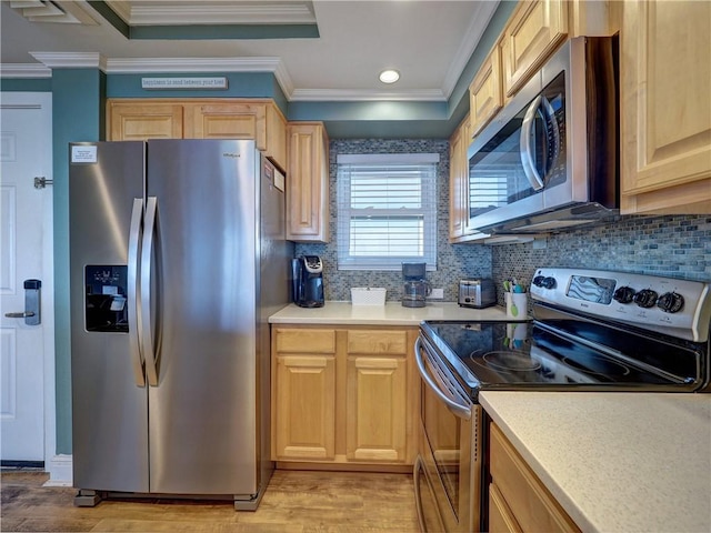 kitchen featuring light hardwood / wood-style floors, crown molding, stainless steel appliances, and tasteful backsplash