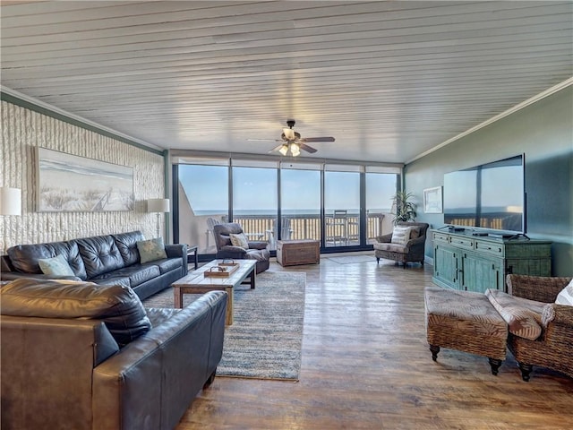 living room featuring ceiling fan, a healthy amount of sunlight, a wall of windows, and wood-type flooring