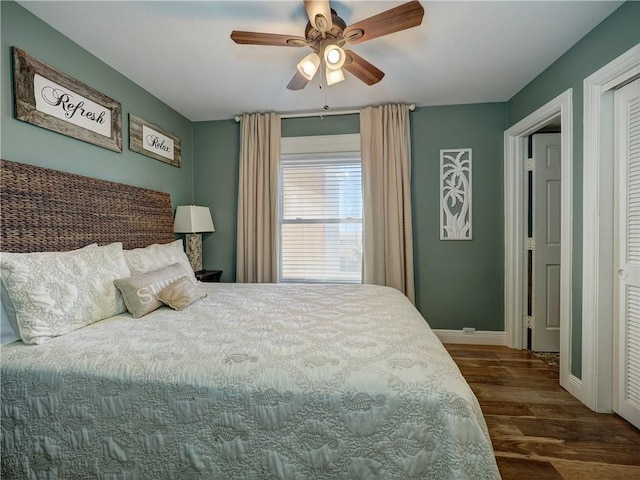 bedroom featuring ceiling fan, dark hardwood / wood-style flooring, and a closet