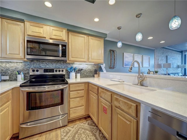 kitchen featuring hanging light fixtures, sink, stainless steel appliances, and ornamental molding