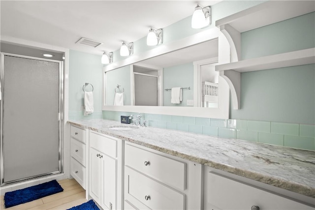 bathroom with walk in shower and vanity