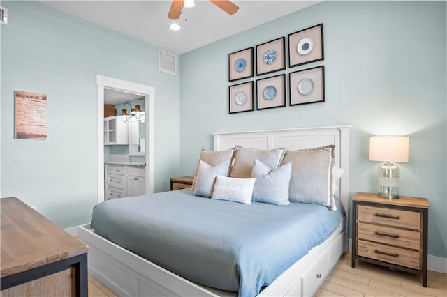 bedroom with ceiling fan, connected bathroom, and light hardwood / wood-style flooring