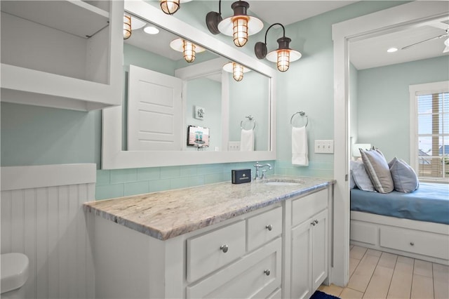 bathroom featuring tasteful backsplash, ceiling fan, and vanity