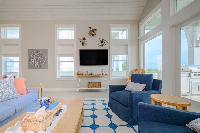 living area with light wood-type flooring, wood ceiling, lofted ceiling, and baseboards