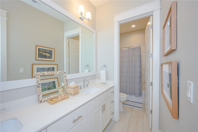 full bath with shower / tub combo, a sink, toilet, and double vanity