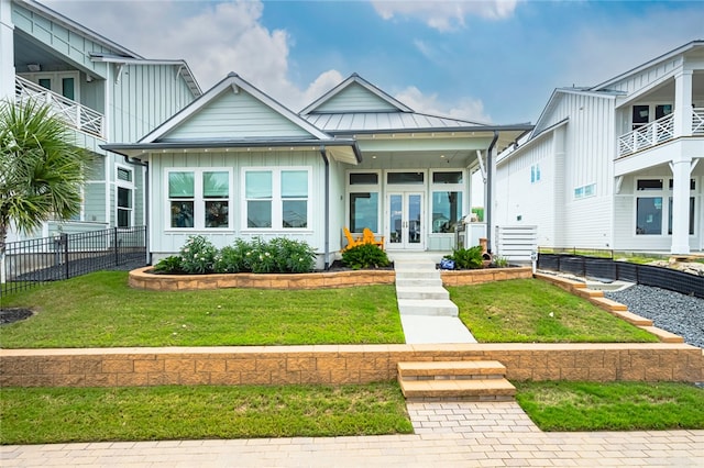 view of front of home featuring a standing seam roof, metal roof, board and batten siding, and a front yard